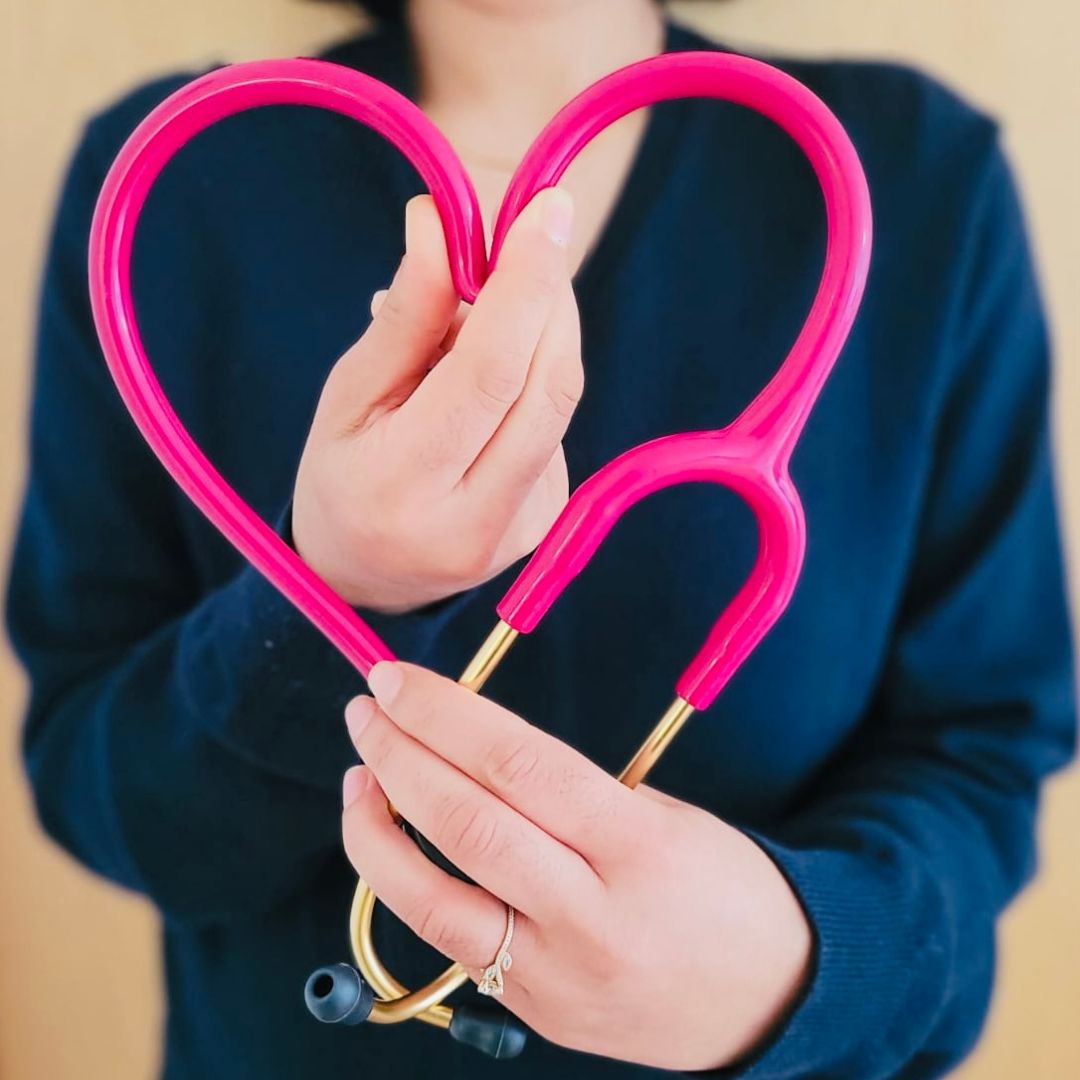 girl in blue jacket holding red and silver ring